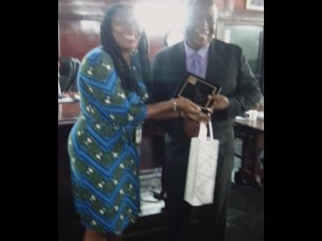 Councillor Pat Harris presents tokens to Spanish Town Deputy Mayor Ralston Wilson in recognition of his decade of service in the post.