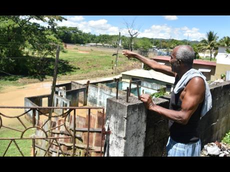 Godfrey Palmer says he and other residents have been repeatedly inconvenienced by the flooded roadway whenever it rains.