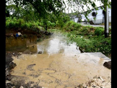 
The section of the Westgate main road in Montego Bay, St James, where the Walters’ family car was washed away in floodwaters last week.