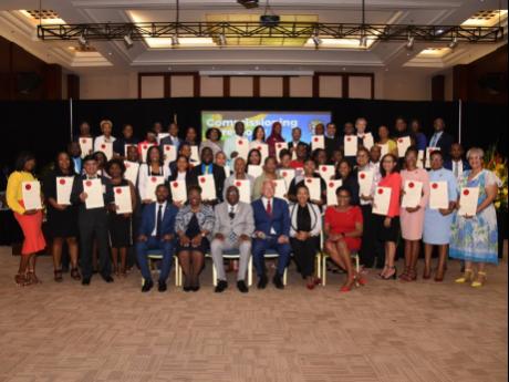 Credit: Ashley Anguin Seated in front (from left): Montego Bay Acting Mayor Richard Vernon; Director of Public Prosecutions Paula Llewellyn; Custos of St James, Bishop Conrad Pitkin; Justice Minister Delroy Chuck; and Maxine Bisasor pose for a group photo with the 48 newly inst