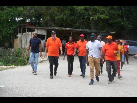 Leader of the Opposition People’s National Party (PNP), Mark Golding (second left), walks the streets and meet the residents of Great River in Hanover, accompanied by PNP caretaker for the Hopewell Division, Jeffrey Brown (fourth left); Councillor for th