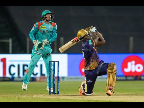 
Kolkata Knight Riders batsman Andre Russell plays a shot during his Indian Premier League game against  the Lucknow Giants. Looking on is Lucknow wicketkeeper, Quinton de Kock.