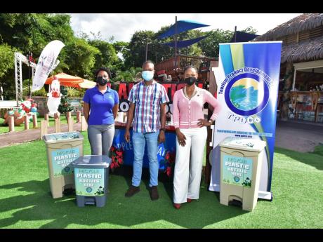 Marketing Manager, Recycling Partners of Jamaica (RPJ), Candace Ming (left) and Project and Business Development Manager, Tourism Product Development Company (TPDCo), Dahlia Dwyer Hodelin (right), hand over  recycling bins for plastic containers to Manager