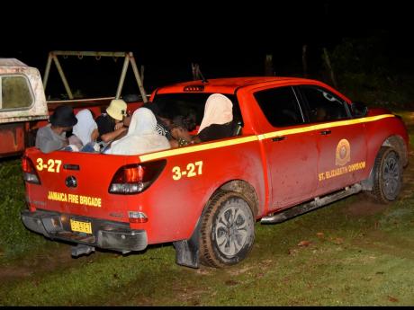 Credit: Ashley Anguin Seven university students being taken away to be reunited with their parents in a Jamaica Fire Brigade vehicle from Irwin Riverside in Montego Bay.