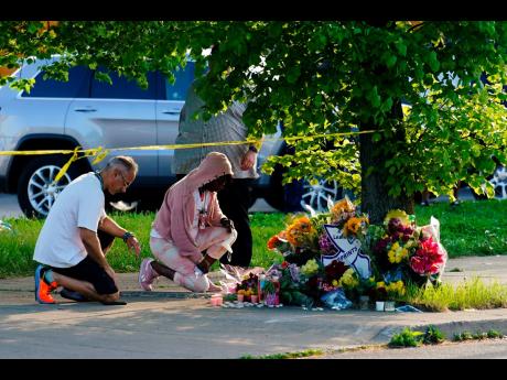 People pay their respects outside the scene of a shooting at a supermarket in Buffalo, New York.