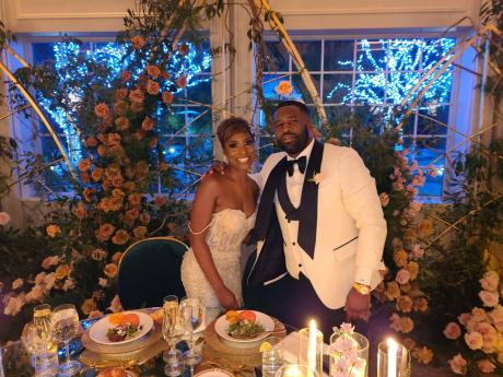 A beaming Sade stands beside the man of her dreams in her dazzling off white, off-the-shoulder fit-and-flare gown.