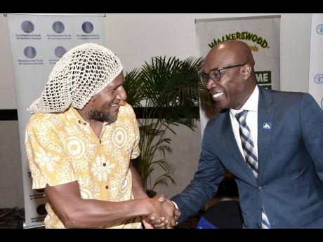 Dr K’adamawe K’nife (left), director of The Centre of Entrepreneurship, Thinking and Practice at The University of the West Indies, Mona, greets Garfield Palmer, chief of JN Bank Small Business Loans, at the Agribusiness Investment Forum, held at The J