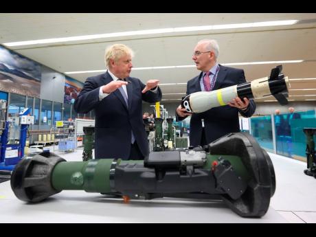 Britain’s Prime Minister Boris Johnson (left) is shown the missile from the inside of an NLAW (Next Generation Light Anti-Tank Weapon) by the managing director of Thales Belfast, Philip McBride, at Thales weapons manufacturer in Belfast, Monday, May 16, 