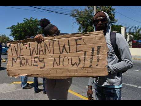 
National Water Commission employees who resorted to industrial action on May 10 stand in protest, calling for better wages and working conditions. 