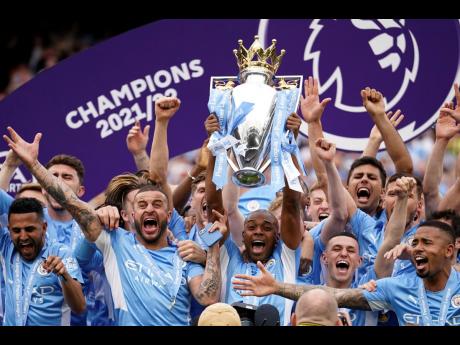 Manchester City players celebrate with trophy after winning the 2022 English Premier League title at the Etihad Stadium in Manchester, England yesterday.