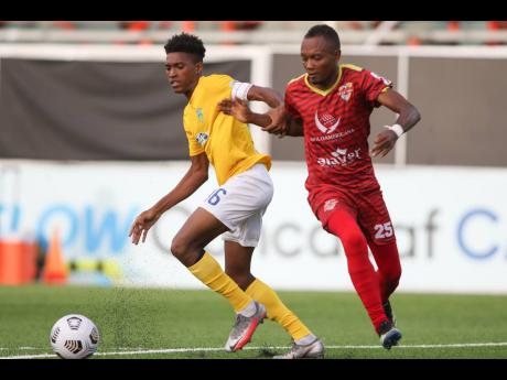 Ky-Mani Campbell  (left) of Waterhouse FC getting away from  Joseph Gomez of Vega Real during the third place match in the FLOW Concacaf Caribbean Club Championship held at the Estadio Cibao stadium in Santiago de los Caballeros, Dominican Republic on Sund