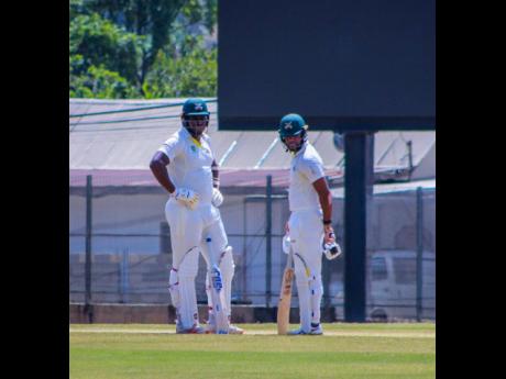 Jamaica Scorpions openers Leroy Lugg (left) and captain John Campbell peruse the scene at the Diego Martin Sports Complex during their West Indies Championship game against the Guyana Harpy Eagles on Saturday. 