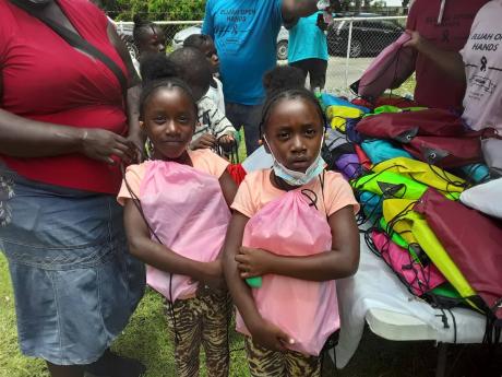 Twins Gabrielle and Gabriella pose with their new pink bags.