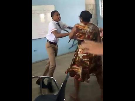 Screen grab of a 16-year-old schoolboy and a 56-year-old teacher brawling at Tivoli Gardens High on Monday.