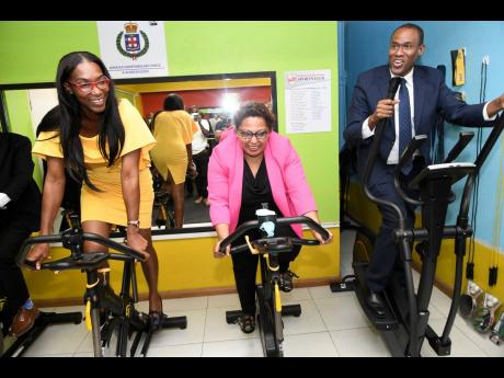 Stacy Smith (left), widow of the late Sergeant Marlon Smith, tests the gym equipment with Hilary Coulton, public relations and administrative manager of the CHASE Fund, and Finance Minister Dr Nigel Clarke at the renaming ceremony of the Protective Service