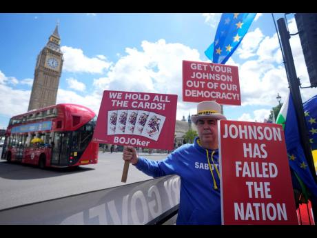 Protesters calling for the removal of British Prime Minister Boris Johnson, demonstrate outside the Houses of Parliament in London last week.