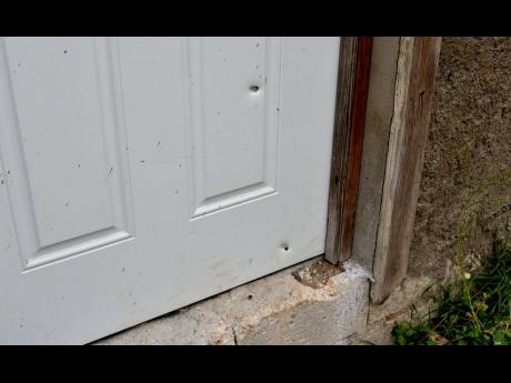 A bullet-riddled door to the house where Jamaica Defence Force reservist, 26-year-old Kemar Dennis, was killed.