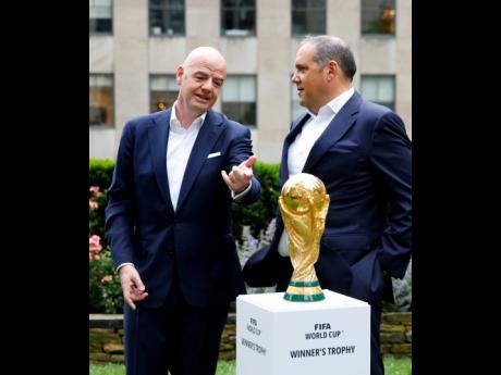 FIFA president Gianni Infantino (left) and FIFA vice president Vittorio Montagliani with the FIFA World Cup Trophy on Thursday, June 16, 2022, in New York.