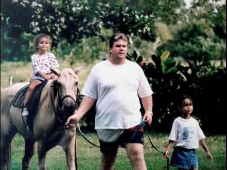 A young Tiffani Ralston (left) and Gabriella Ralston taking a ride with their father, John.