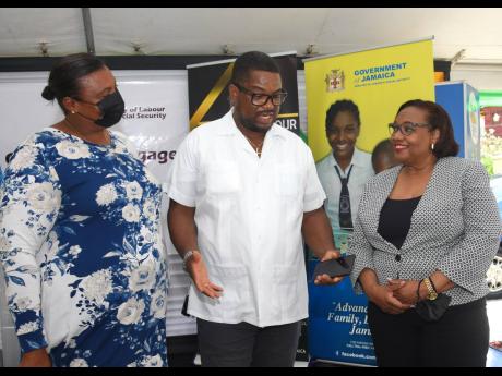 Credit: Ashley Anguin/Photographer Heroy Clarke (centre), member of parliament for St James Central, speaks with Deon Stern-Anglin (left), acting principal of Corinaldi Primary School, and Audrey Deer-Williams, chief technical director with responsibility for the Social Security Division of