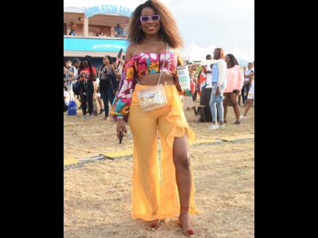 Tanisha Westcarr dressed up her PrettyLittleThing pants with an off-the-shoulder crop top by the Cameroonian-fronted Grass-field.