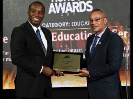 Ricardo Allen (left), founder and CEO of One-on-One Educational Services, is presented the RJRGLEANER Honour Award for Education by Christopher Barnes, chief operating officer of the RJRGLEANER Communications Group. One-on-One Educational Services earned t