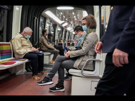 People wearing face masks to protect against COVID-19 ride a subway in Paris, France, last Thursday, June 30.