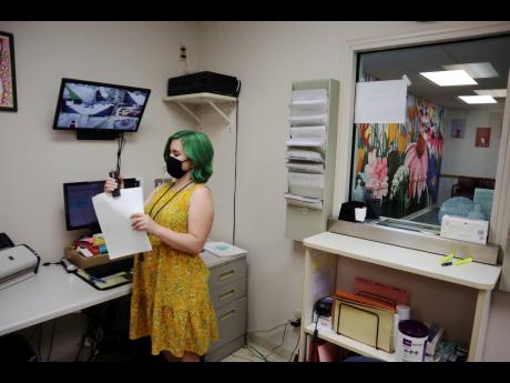 Beth Fiddler, a receptionist and telephone counsellor at the Women’s Health Center of West Virginia, staples paperwork in her office outside the clinic’s empty waiting room.