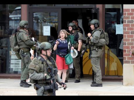 Law enforcement officers help evacuate people from an Anthropologie store in Highland Park, Illinois, on Monday, after a shooter fired on the northern suburb’s Fourth of July parade.