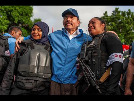 In this 2018 photo, Nicaraguan police have their picture taken with President Daniel Ortega, in Masaya, Nicaragua. United States announced on June 13 that is restricting visas to members of the government of Nicaragua for having undermined democracy after 