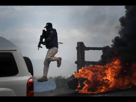 A police officer abandons his vehicle during a demonstration that turned violent in which protesters demanded justice for the assassinated President Jovenel Moise in Cap-Haitien, Haiti, on July 22, 2021.