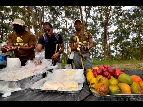 A trekker reaches for a bag with fruits at one of the rest stops along the trail. 