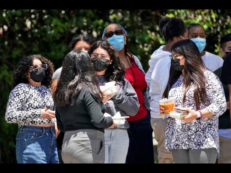 People wear a face mask while waiting at a bus stop along Hill Street Wednesday, July 13, 2022, in Los Angeles. Los Angeles County might be imposing a mask mandate on July 29 if COVID-19 numbers continue to rise. (AP Photo/Marcio Jose Sanchez)
