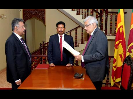 In this photograph provided by the Sri Lankan President’s Office, Ranil Wickremesinghe takes oath as the interim president in Colombo, Sri Lanka, on Friday, July 15.