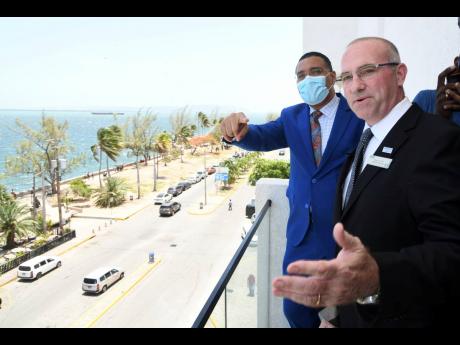 Jaap van Dam (right), general manager of the ROK Hotel Kingston, and Prime Minister Andrew Holness take in a view of the waterfront from the balcony of the ROK Hotel Kingston on Tuesday. They were attending the hotel’s official opening.