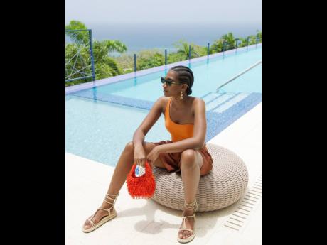 Credit: Wade Rhode Shielding from the rays of the sun in Isle of Eden specs, Tash Ogeare wears a one-shoulder Ted Baker piece, crepe linen stretch talbot shorts by Joseph, Armani Exchange knotted lace up sandals and clutches a Mango beaded fringe bag.