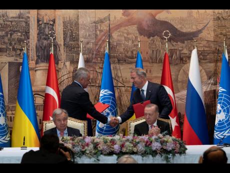 Turkish President Recep Tayyip Erdogan (right) and UN Secretary General Antonio Guterres sit as Sergei Shoigu (left), Russia’s Defence Minister, and Hulusi Akar, Turkey’s Defence Minister, shake hands during a signing ceremony at Dolmabahce Palace in I