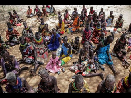 Villagers gather during a visit by United Nations Under-Secretary-General for Humanitarian Affairs Martin Griffiths, in the village of Lomoputh in northern Kenya on May 12. Griffiths visited the area on Thursday to see the effects of the drought which the 