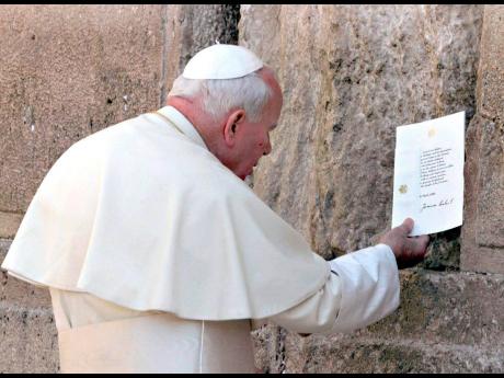 Pope John Paul II places a typed and signed note into a crack at the Western Wall in 2000, in Jerusalem’s Old City. He tucked the prayer note into the wall asking God’s forgiveness for those who “have caused these children of yours to suffer.” 
