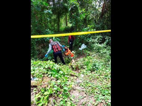 Credit: Photo by Ruddy Mathison Crime-scene detectives attempting to access the forested area near Job Lane, Spanish Town, where the bodies of two men were found Thursday.