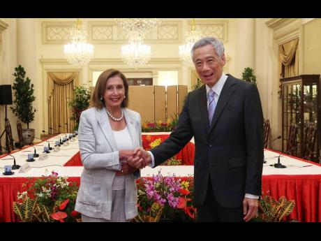 In this photo provided by Ministry of Communications and Information, Singapore, US House Speaker Nancy Pelosi and Prime Minister Lee Hsien Loong shake hands at the Istana Presidential Palace in Singapore on Monday, August 1.