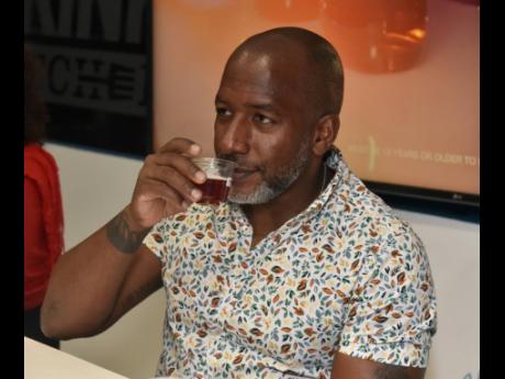 Credit: Kenyon Hemans Taking a sniff and recognising the oaky notes in the Appleton Estate rum was Photographer Dwayne Watkins.