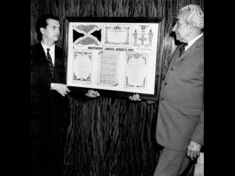 
In this August 23, 1962 file photo, Minister of Development and Welfare Edward Seaga (left) presents the first framed copy of the colour poster produced by the Government Public Relations Office to the Prime Minister Sir Alexander Bustamante.