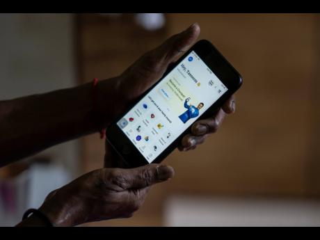 Credit: AP A woman shows her account at Policybazaar using an app on her phone in Mumbai, India, on Wednesday, August 10.