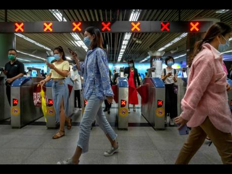 
Commuters walk through a subway station during the morning rush hour in the central business district in Beijing, on Tuesday, August 9.