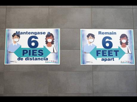 FILE - Signs on the wall remind students to keep 6 feet apart during a media tour of the Norris Middle School in Omaha, Nebraska, on Wednesday, July 29, 2020. 