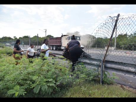 Top: In defiance of repeated warnings, pedestrians still risk crossing the busy highways, often breaking down the barriers built to keep them out and ignoring the possibility of being penalised. 