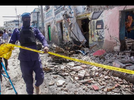 A member of the security force cordons off wreckage at the scene after gunmen stormed a hotel in the capital, Mogadishu. 