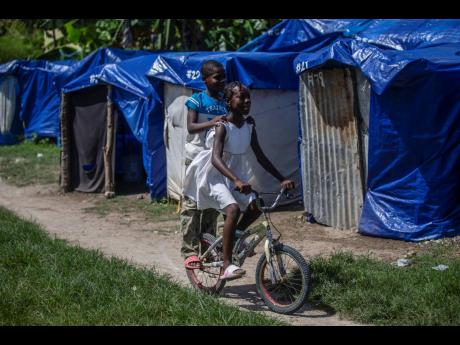 Children cycle through Camp Devirel, set up by people left homeless by last year’s 7.2-magnitude earthquake, in Les Cayes, Haiti. UNICEF has warned that more than 250,000 children still have no access to adequate schools, and that the majority of the 1,2