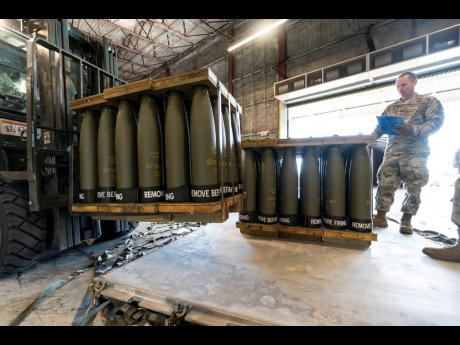 FILE - US Air Force Staff Sgt Cody Brown, with the 436th Aerial Port Squadron, checks pallets of 155 mm shells ultimately bound for Ukraine, April 29, at Dover Air Force Base, Delaware. 